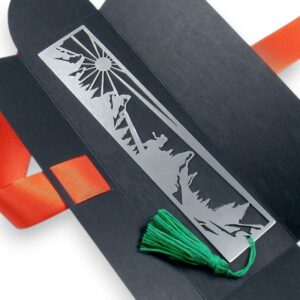 Metalowa zakładka z zachodem słońca nad górami udekorowana chwostem.