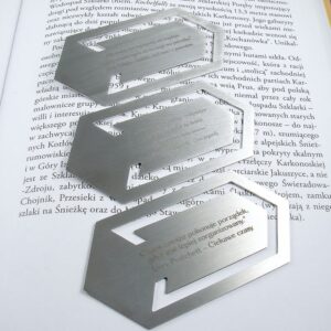 Metalowe zakładki cytatami z książek. 